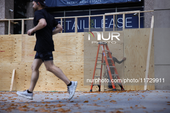 A person jogs past boarded up storefronts near the White House in Washington, D.C. on November 1, 2024 as local busineses prepare for possib...