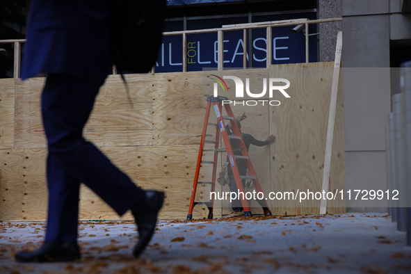 A person walks past boarded up storefronts near the White House in Washington, D.C. on November 1, 2024 as local busineses prepare for possi...