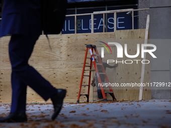 A person walks past boarded up storefronts near the White House in Washington, D.C. on November 1, 2024 as local busineses prepare for possi...