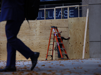 A person walks past boarded up storefronts near the White House in Washington, D.C. on November 1, 2024 as local busineses prepare for possi...