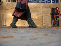 A person walks past boarded up storefronts near the White House in Washington, D.C. on November 1, 2024 as local busineses prepare for possi...