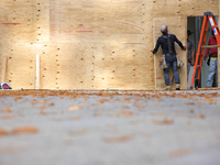 Workers cover storefront entrances with plywood near the White House in Washington, D.C. on November 1, 2024 in preparation for possible civ...