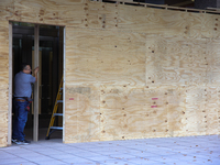 Workers cover storefront entrances with plywood near the White House in Washington, D.C. on November 1, 2024 in preparation for possible civ...