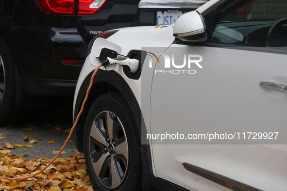 An electric car charges in front of a home in Vaughan, Ontario, Canada, on October 31, 2024. 