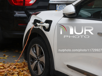 An electric car charges in front of a home in Vaughan, Ontario, Canada, on October 31, 2024. (