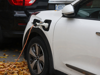 An electric car charges in front of a home in Vaughan, Ontario, Canada, on October 31, 2024. (