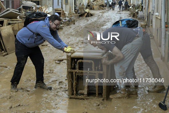 People clear mud and possessions from their homes after flash flooding in Paiporta, Spain, on November 1, 2024. 