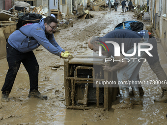 People clear mud and possessions from their homes after flash flooding in Paiporta, Spain, on November 1, 2024. (