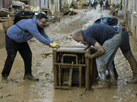 People clear mud and possessions from their homes after flash flooding in Paiporta, Spain, on November 1, 2024. (