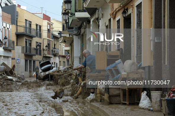 People clear mud and possessions from their homes after flash flooding in Paiporta, Spain, on November 1, 2024. 