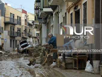 People clear mud and possessions from their homes after flash flooding in Paiporta, Spain, on November 1, 2024. (