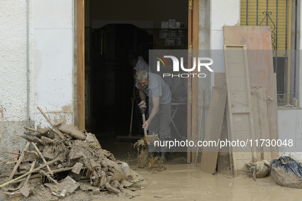 People clear mud and possessions from their homes after flash flooding in Paiporta, Spain, on November 1, 2024. 