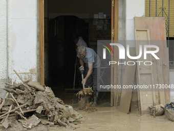 People clear mud and possessions from their homes after flash flooding in Paiporta, Spain, on November 1, 2024. (