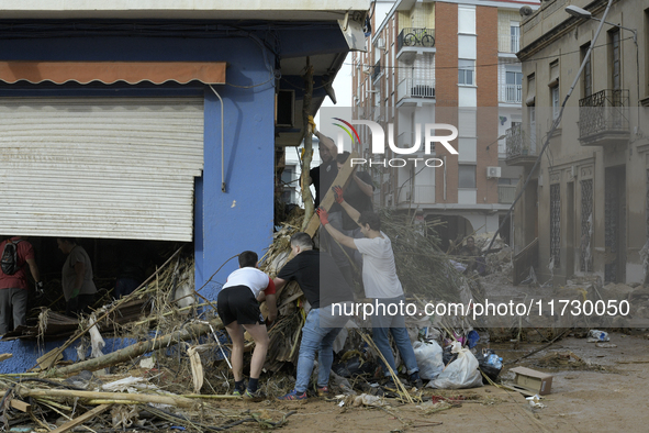 People clear mud and possessions from their homes after flash flooding in Paiporta, Spain, on November 1, 2024. 