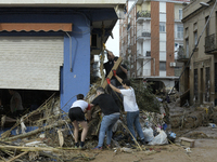 People clear mud and possessions from their homes after flash flooding in Paiporta, Spain, on November 1, 2024. (