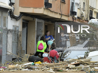 People clear mud and possessions from their homes after flash flooding in Paiporta, Spain, on November 1, 2024. (