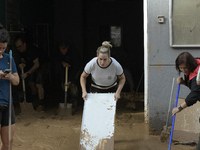 People clear mud and possessions from their homes after flash flooding in Paiporta, Spain, on November 1, 2024. (