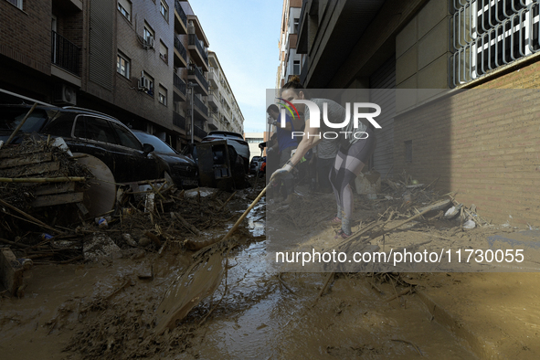 People clear mud and possessions from their homes after flash flooding in Paiporta, Spain, on November 1, 2024. 