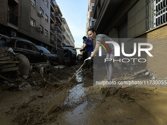 People clear mud and possessions from their homes after flash flooding in Paiporta, Spain, on November 1, 2024. (