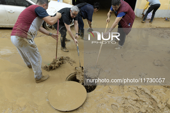 People clear mud and possessions from their homes after flash flooding in Paiporta, Spain, on November 1, 2024. 