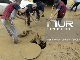 People clear mud and possessions from their homes after flash flooding in Paiporta, Spain, on November 1, 2024. (