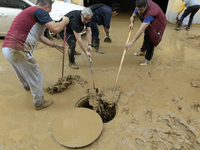 People clear mud and possessions from their homes after flash flooding in Paiporta, Spain, on November 1, 2024. (