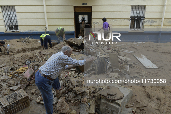 People clear mud and possessions from their homes after flash flooding in Paiporta, Spain, on November 1, 2024. 