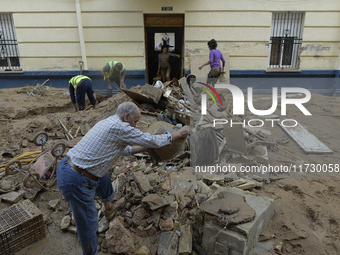 People clear mud and possessions from their homes after flash flooding in Paiporta, Spain, on November 1, 2024. (