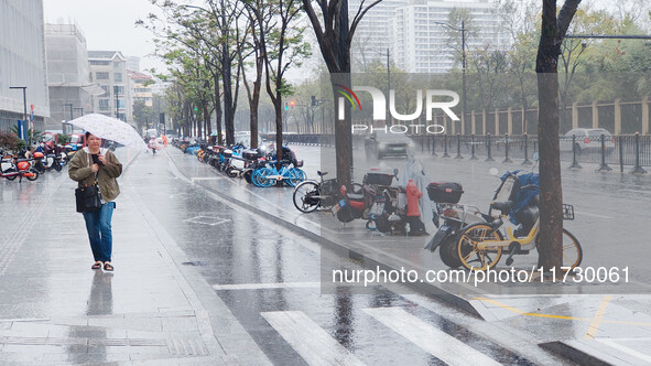 A pedestrian walks with an umbrella as Typhoon Kong-Rey brings strong winds and heavy rain in Shanghai, China, on November 1, 2024. 