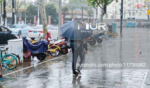 A pedestrian walks with an umbrella as Typhoon Kong-Rey brings strong winds and heavy rain in Shanghai, China, on November 1, 2024. 