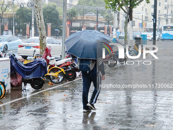 A pedestrian walks with an umbrella as Typhoon Kong-Rey brings strong winds and heavy rain in Shanghai, China, on November 1, 2024. (