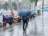 A pedestrian walks with an umbrella as Typhoon Kong-Rey brings strong winds and heavy rain in Shanghai, China, on November 1, 2024. (