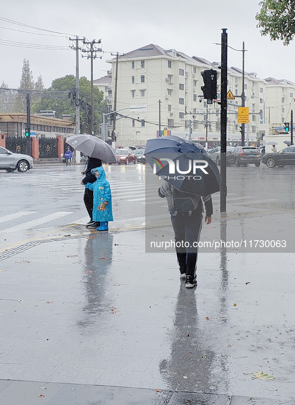 A pedestrian walks with an umbrella as Typhoon Kong-Rey brings strong winds and heavy rain in Shanghai, China, on November 1, 2024. 