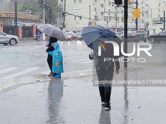 A pedestrian walks with an umbrella as Typhoon Kong-Rey brings strong winds and heavy rain in Shanghai, China, on November 1, 2024. (