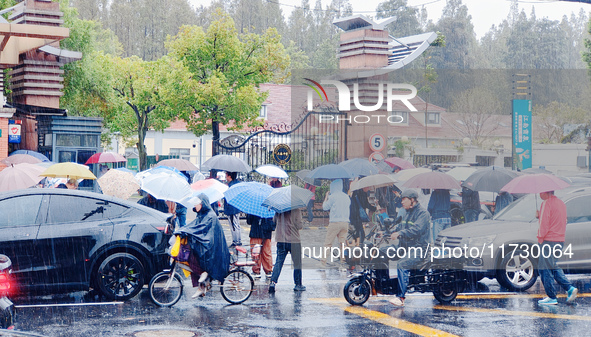 Parents hold umbrellas to pick up their children from school after Typhoon Kong-Rey brings strong winds and heavy rain in Shanghai, China, o...