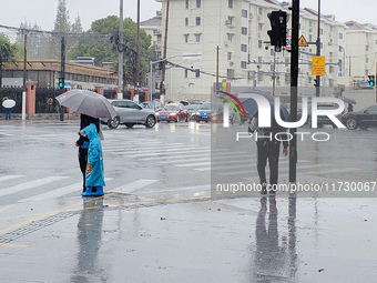 A pedestrian walks with an umbrella as Typhoon Kong-Rey brings strong winds and heavy rain in Shanghai, China, on November 1, 2024. (