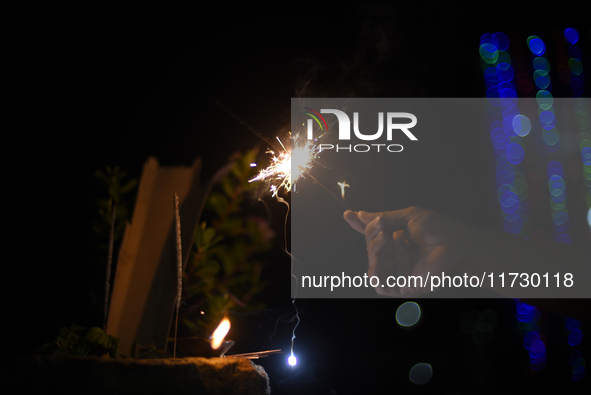 A boy smiles while holding sparklers during Laxmi Puja as part of the Tihar or Deepawali and Diwali celebrations in Kathmandu, Nepal, on Nov...