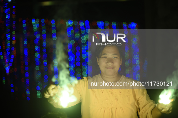 A woman holds sparklers during Laxmi Puja as part of the Tihar or Deepawali and Diwali celebrations in Kathmandu, Nepal, on November 1, 2024...