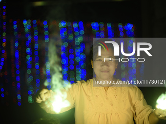 A woman holds sparklers during Laxmi Puja as part of the Tihar or Deepawali and Diwali celebrations in Kathmandu, Nepal, on November 1, 2024...