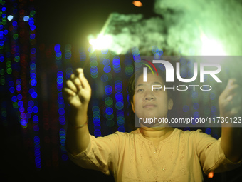 A woman holds sparklers during Laxmi Puja as part of the Tihar or Deepawali and Diwali celebrations in Kathmandu, Nepal, on November 1, 2024...