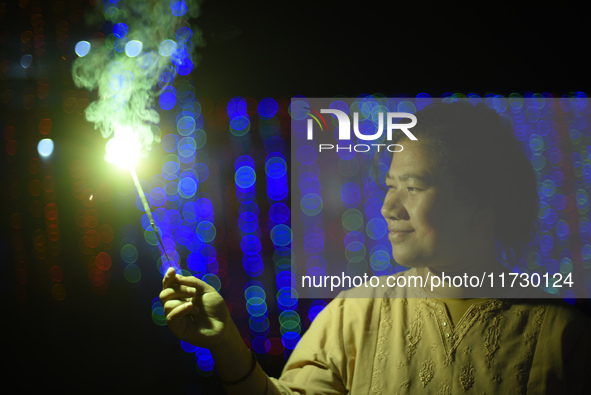 A woman holds sparklers during Laxmi Puja as part of the Tihar or Deepawali and Diwali celebrations in Kathmandu, Nepal, on November 1, 2024...