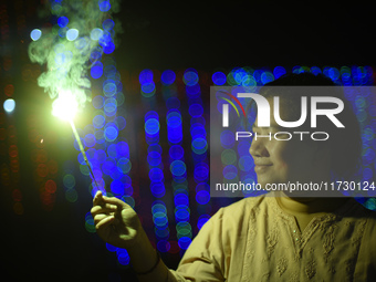 A woman holds sparklers during Laxmi Puja as part of the Tihar or Deepawali and Diwali celebrations in Kathmandu, Nepal, on November 1, 2024...