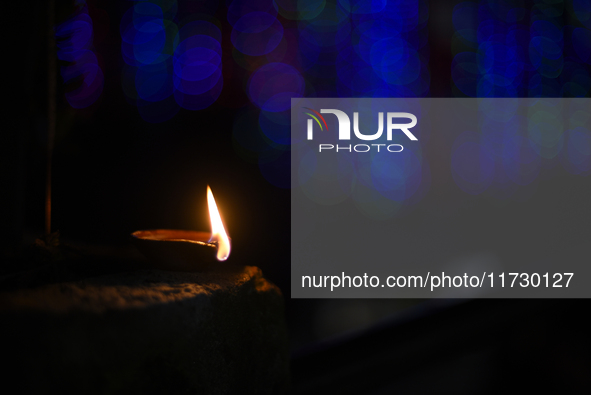 A devotee offers clay pot lamps during Laxmi Puja as part of the Tihar or Deepawali and Diwali celebrations in Kathmandu, Nepal, on November...