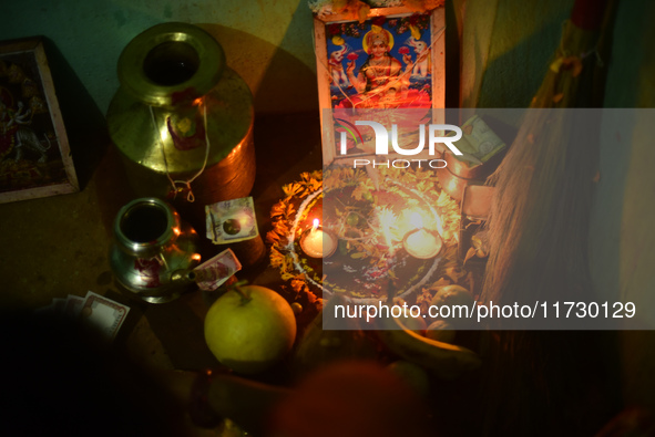 A Nepalese devotee offers a ritual prayer towards a poster of Laxmi Puja during the procession of Tihar or Deepawali and Diwali celebrations...