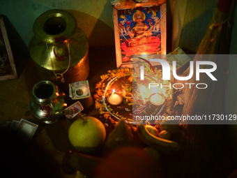 A Nepalese devotee offers a ritual prayer towards a poster of Laxmi Puja during the procession of Tihar or Deepawali and Diwali celebrations...