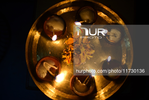 A devotee offers clay pot lamps during Laxmi Puja as part of the Tihar or Deepawali and Diwali celebrations in Kathmandu, Nepal, on November...