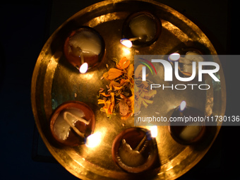 A devotee offers clay pot lamps during Laxmi Puja as part of the Tihar or Deepawali and Diwali celebrations in Kathmandu, Nepal, on November...