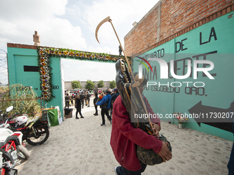 A faithful carries a Santa Muerte image to bless it at the temple of Santa Muerte in the municipality of Pedro Escobedo, Mexico, on November...