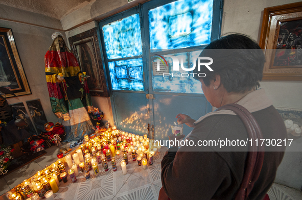 A faithful attends the temple of Santa Muerte in the municipality of Pedro Escobedo, Mexico, on November 1, 2024, to worship her and give th...