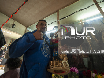 A faithful attends the temple of Santa Muerte in the municipality of Pedro Escobedo, Mexico, on November 1, 2024, to worship her and give th...